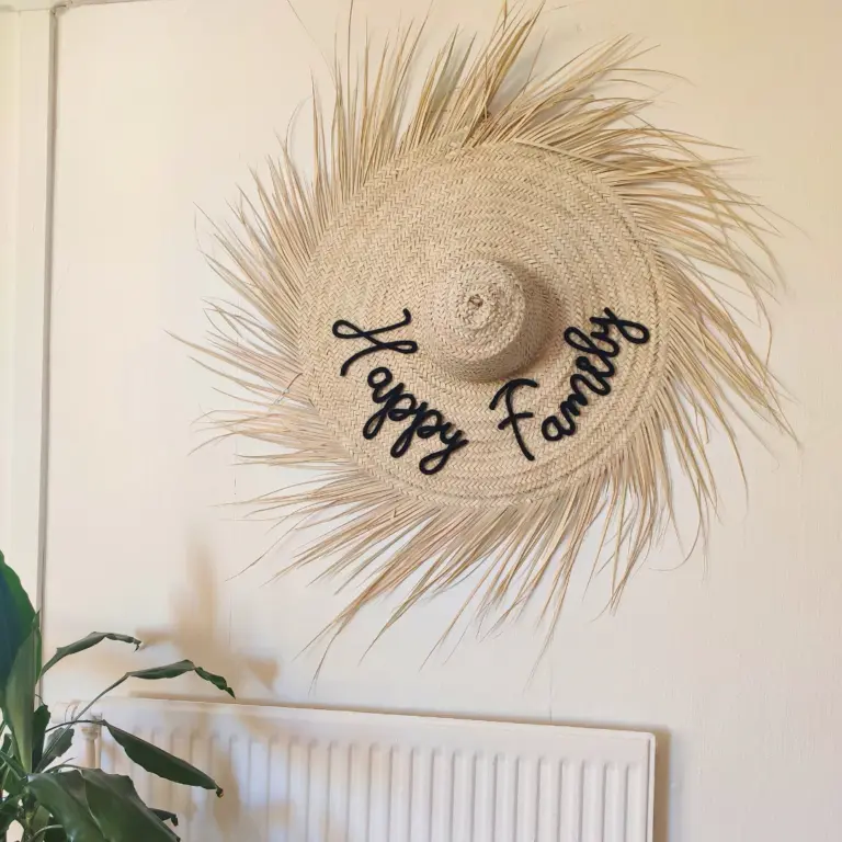 Elevate your space with this handwoven palm leaf wall hat with natural raffia fringes, blending authentic craftsmanship and boho charm. Made from sustainable materials, each piece is unique and eco-friendly. ✨ Why you’ll love it: Authentic Craftsmanship – Handwoven with care, showcasing natural variations that make every hat one of a kind. Natural Materials – Crafted from lightweight, durable palm leaves. Boho Fringe Design – Adds texture and warmth, perfect for wall décor or practical use. Customizable – Personalize with a name or meaningful word in the color of your choice for a unique touch. 📏 Available Sizes: S: 50 cm diameter (without fringes) L: 60 cm diameter (without fringes) 👉 A personalized boho statement piece that doubles as wall art and a thoughtful gift, bringing nature and style into your home.